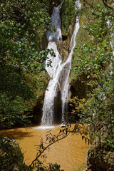 Fototapeta na wymiar Topes de Collantes, Cuba - July 19, 2018: Waterfall in a lush rainforest. Vegas grande waterfall in Topes de Collantes, Trinidad, Cuba