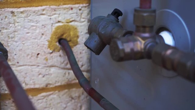 Water dripping from defected installation mounted on the side of the house.