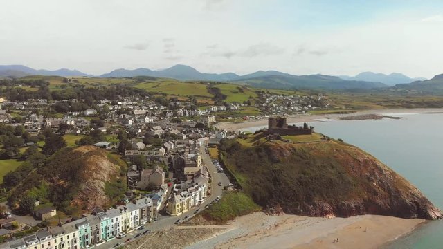 Criccieth - Pearl of Wales on the Shores of Snowdonia - aerial drone image rising above 11th century Criccieth Castle and Dinas, with views towards Snowdonia - 4K 23.89fps