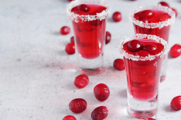 Three cranberry liquor shots with whole berries	