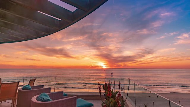 Stunning time lapse from luxury home at golden hour with a coastal sunset and blue and orange color sky.