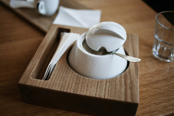 Beautiful sugar bowl on the brown table in the cafe