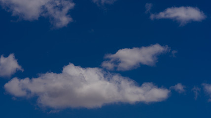 white clouds float across the blue sky