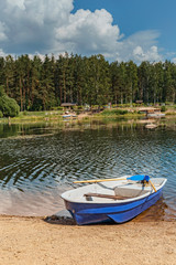 Fototapeta na wymiar a small pleasure boat on the shore of a quiet lake in a recreation area near St. Petersburg, Russia