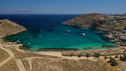 Aerial drone photo of small peninsula with picturesque chapel and beach of Agia Anna as well as small beach of Divounia, island of Mykonos, Cyclades, Greece