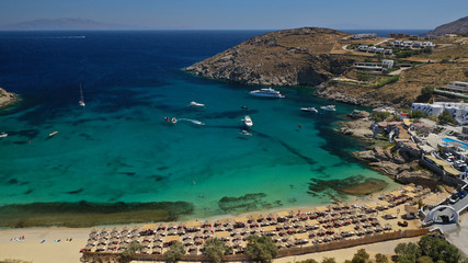 Obraz premium Aerial drone photo of small peninsula with picturesque chapel and beach of Agia Anna as well as small beach of Divounia, island of Mykonos, Cyclades, Greece