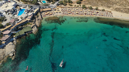 Aerial drone photo of small peninsula with picturesque chapel and beach of Agia Anna as well as small beach of Divounia, island of Mykonos, Cyclades, Greece