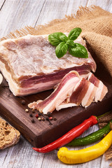 Homemade Chunks of salted bacon on a cutting rustic board