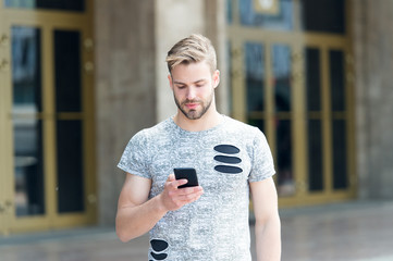 Urban wifi coverage. Download application. Man hold smartphone building background. Man messaging...