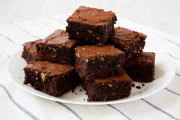 Homemade chocolate brownies on a white plate, side view. Close-up.