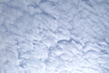White cotton candy clouds against blue sky for background backdrop 