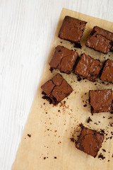 Homemade chocolate brownies on a baking sheet on a white wooden surface, top view. Flat lay,...