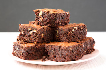 Homemade chocolate brownies on a pink plate, side view. Closeup.