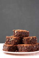 Homemade chocolate brownies on a pink plate, side view. Close-up.
