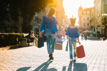 sale, consumerism, money and people concept - happy young woman with shopping bags and credit card in mall