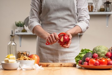 The chef prepares a vegetarian salad with the hand of a chef in the home kitchen. Light background with text area for restaurant menu design. The concept of healthy eating, cooking salad