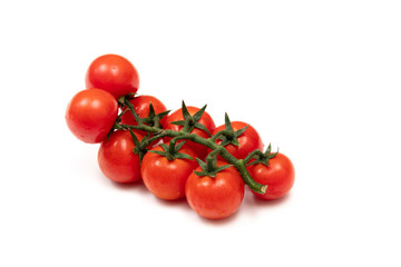 A branch of red cherry tomatoes on a white background. Small and juicy vegetable is rich in vitamins and trace elements. Healthy food. Fresh and organic vegetables. Raw food
