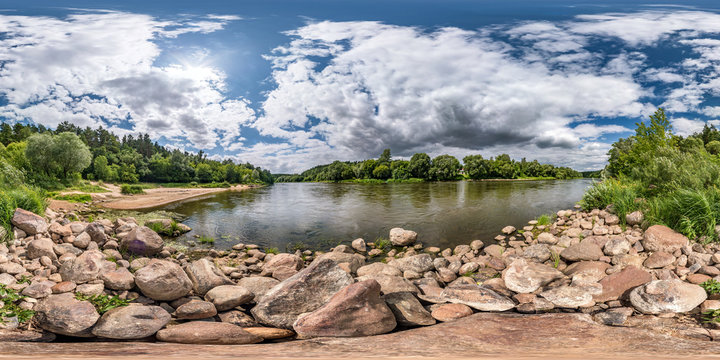 full spherical seamless hdri panorama 360 degrees angle view on rocky shore of huge river in sunny summer day and windy weather with beautiful clouds in equirectangular projection, VR content