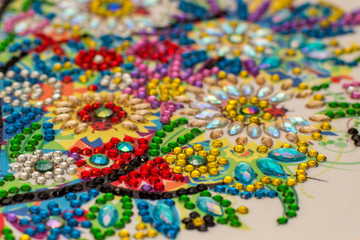 Diamond painting embroidery craft.  Acrylic rhinestones. Closeup, selective focus