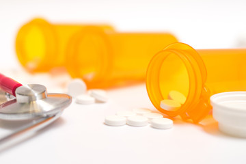 Paracetamol medicine or aspirin drrug in doctor prescription bottle and medical stethoscope on white background with copyspace.