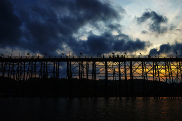 Fototapeta premium WOODEN MON BRIDGE with clouds and sunlight Sangkhlaburi,&nbsp;Sangkhla Buri,&nbsp;Kanchanaburi Thailand