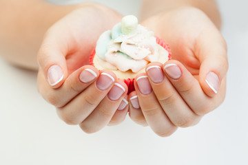 Beauty manicure. Woman's hands with nails holding puncake