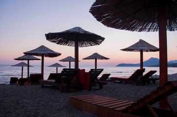 sunset on the sea beach on the background of beach umbrellas