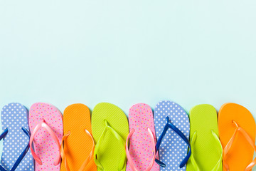 a lot of flip flop colored sandals, summer vacation on colored background, copy space top view