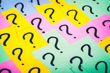 Question marks background. Colorful paper notes with question marks. Concept image. Closeup top view toned