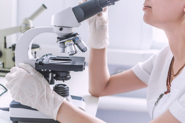 Hands with microscope in the laboratory