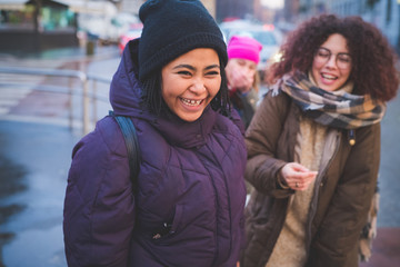 young women standing in the street and smiling