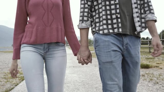 Romantic young couple walking and holding hands