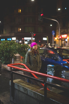 young woman standing close metro station and looking ahead