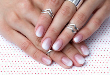 Two hands with manicure at the creative polka dot background. © Darya Lavinskaya
