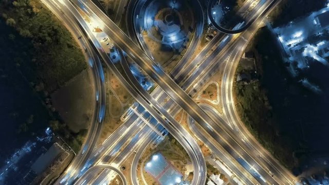 Hyperlapse timelapse of night city traffic on 4-way stop street intersection circle roundabout in bangkok at night, thailand. 4K UHD horizontal aerial view.