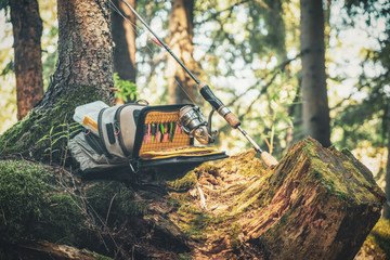Bag with fishing essentials at riverside on sunny day