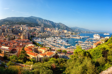 Fototapeta na wymiar Panoramic view of Monaco harbor, Monte Carlo. Scenic summer cityscape with buildings, mountains, luxury yachts and blue sky, Cote d'Azur, microstate of the French Riviera, outdoor travel background