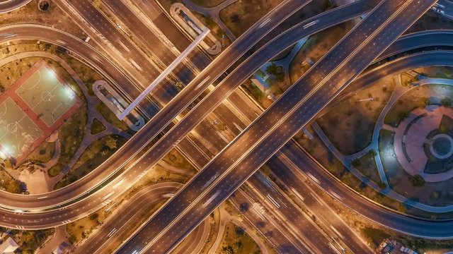 Hyperlapse timelapse of night city traffic on 4-way stop street intersection circle roundabout in bangkok at night, thailand. 4K UHD horizontal aerial view.Zoom out.