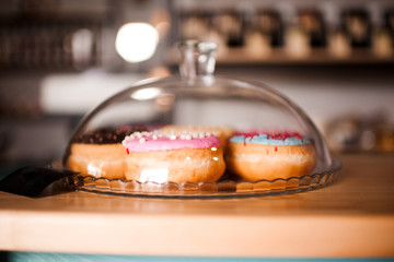 Fresh colorful donuts in cafe closeup