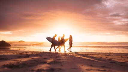 People walking on beach during sunset