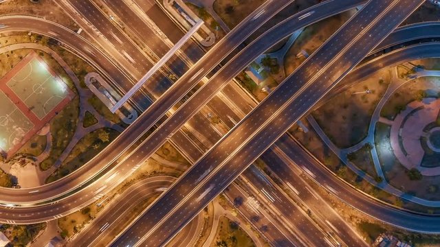 Hyperlapse timelapse of night city traffic on 4-way stop street intersection circle roundabout in bangkok at night, thailand. 4K UHD horizontal aerial view.Zoom in.