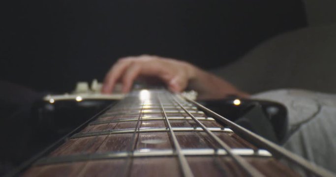 Closeup shoot of guitar with strings being hold by a musician with background isolated on black