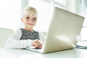 Smiling girl as typist at the laptop