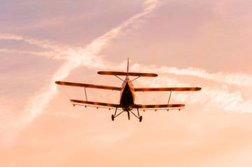 View on an old plane flying during the sunset