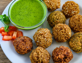 Close up of fresh falafel balls with pesto sauce.