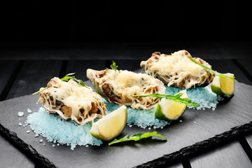 seafood  with cheese and lime on a slate plate on black wooden  background