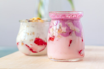 healthy products for breakfast, granola and fresh berries on white table
