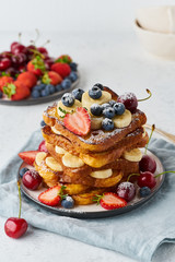 French toasts with berries and banana, brioche breakfast, white background, vertical closeup