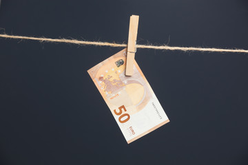 Billetes de euro, colgados de una cuerda sujetos por pinzas de madera de extender la ropa