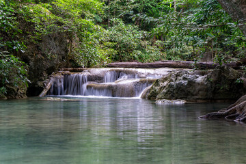 Fototapeta na wymiar Clean green emerald water from the waterfall Surrounded by small trees - large trees, green colour, Erawan waterfall, Kanchanaburi province, Thailand